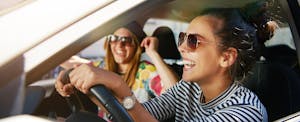 college-graduate-car-buying-guide Laughing trendy young college graduates in sunglasses traveling in a car in town, happy because they just bought their first car after graduation