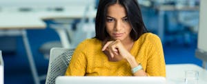 Woman looking at a laptop and trying to create a strong password