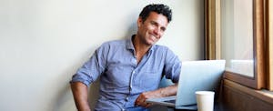 Young man smiling because he has the highest credit score, and can teach you how to get your fico score and other credit scores.