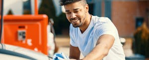 Young man cleaning his newly refinanced car Young man cleaning his newly refinanced car