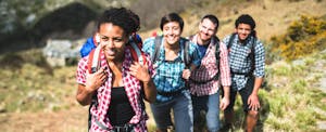 Group of young hikers walking up mountain