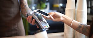 Customer paying for her coffee by mobile payment