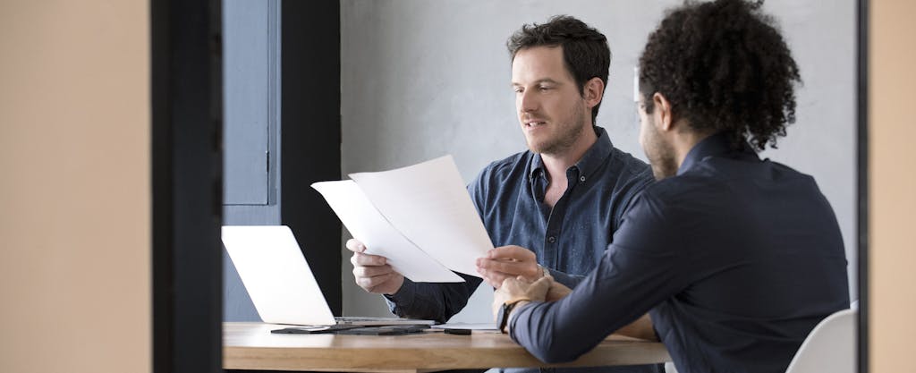 Men in office reviewing document