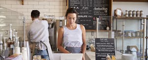 Couple working behind the counter at a coffee shop