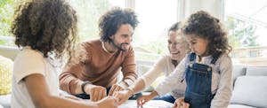 Family sitting around a table, playing a matching game