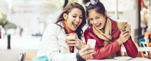 Two women enjoying a cup of coffee outdoors