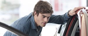 Man looking at the inside of a car