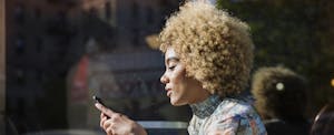 Woman sitting at a table and reading from her phone