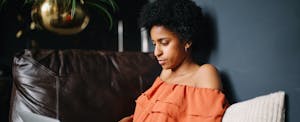 Woman sitting at home, using her computer to look up how to file for unemployment