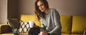 Woman drinking coffee and looking up payday loans in California