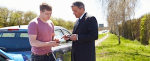 Two drivers exchanging information after a car accident