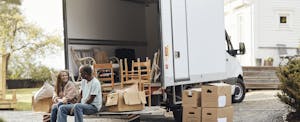 best-states-for-first-time-homebuyers Couple talking to each other while sitting by cardboard boxes near van