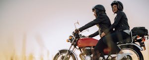 foremost Young couple taking a break while riding a vintage motorcycle through the countryside