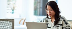 best-usage-based-insurance-companies Woman using her computer at home